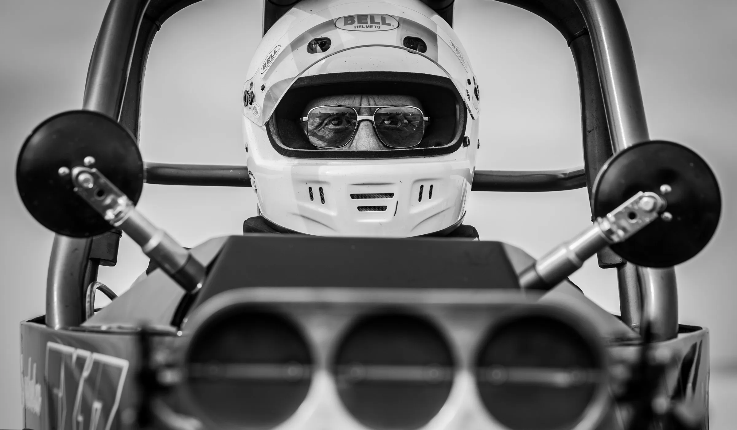 Fahrer mit Helm und Schutzbrille im Cockpit eines Dragsters